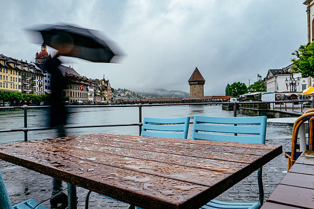 istock People With Umbrella Walking On Sidewalk Along River During Rain 660575063