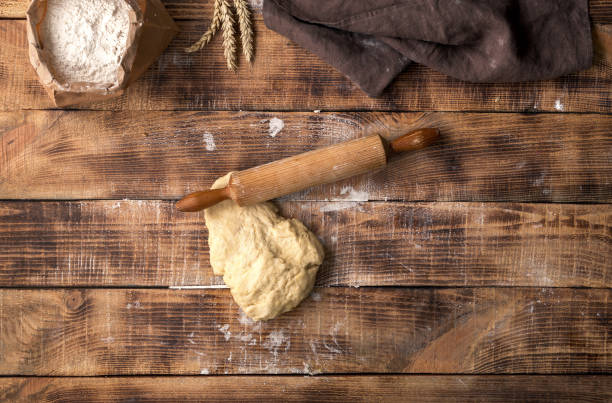istock Fresh dough with rolling pin and flour on a wooden table 660582784