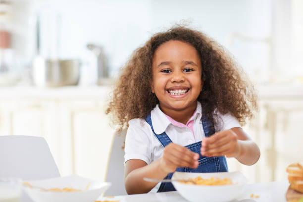 おかしい小さな女の子がスパゲッティを食べる - child eating pasta spaghetti ストックフォトと画像