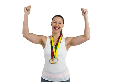 Portrait of Female athlete posing with gold medal after victory on white background