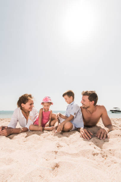 istock Young smiling family relaxing in sand on the beach. 660606540