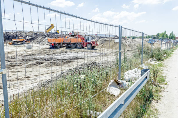 istock Bulldozer is loading a truck on building site in fenced area 660610342