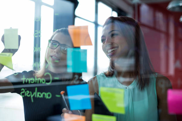 istock Business executives writing over sticky notes on glass 660610834
