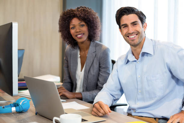 istock Smiling business people sitting in office 660611262