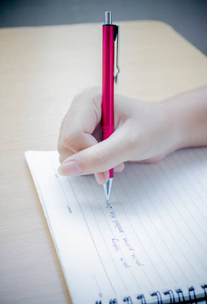 istock close up of woman's hand writing 660617540