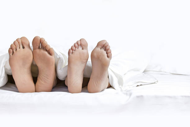 ベッドの上のカップルの足 - bed couple human foot heterosexual couple ストックフォトと画像