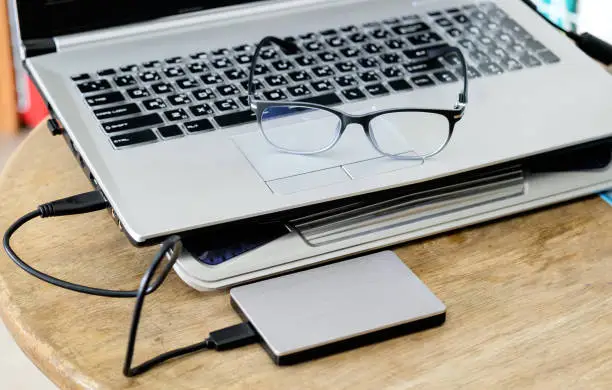 Photo of Notebook grey modern black keyboard with hdd grey and spectacles