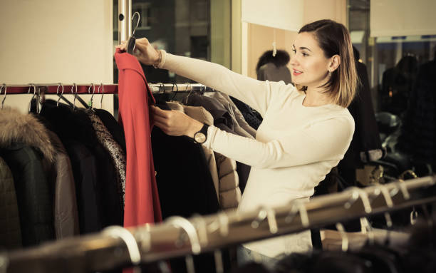 istock Charming female customer examining red woolen coat 660629478
