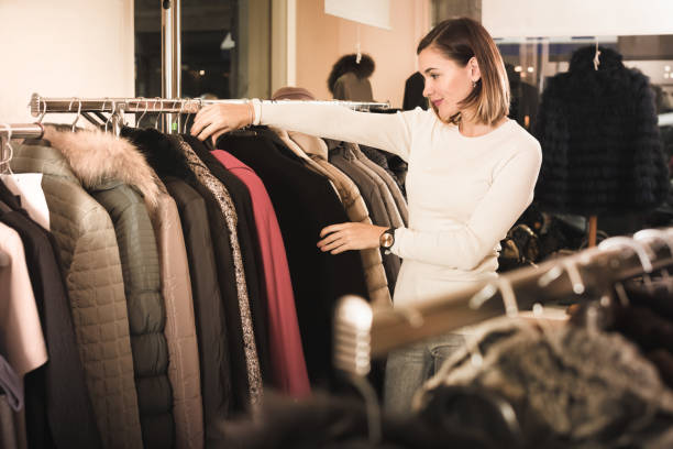 istock Young female customer examining red woolen coat 660629484