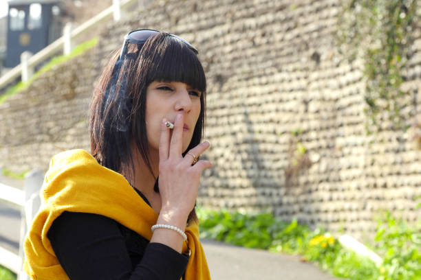 istock young brunette woman smoking  cigarette outside 660630328