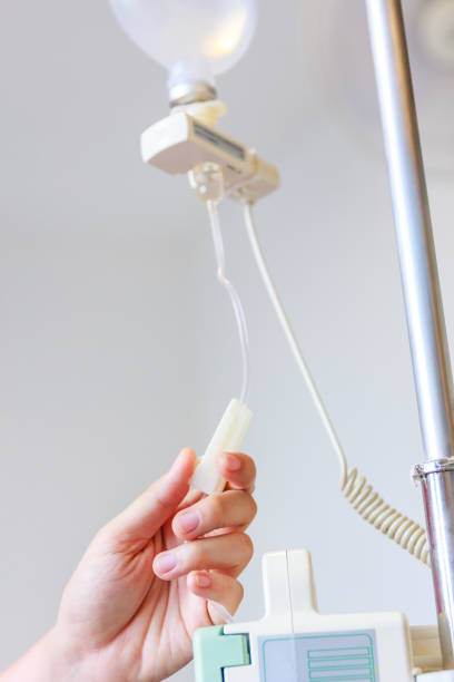 istock Nurse's hands regulation an intravenous (IV) drip in hospital room. 660630352
