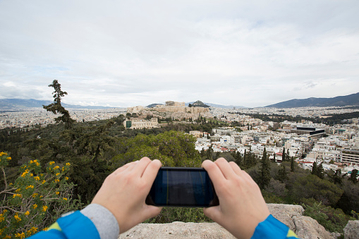 Boy photographing aerial view on city and Acropolis