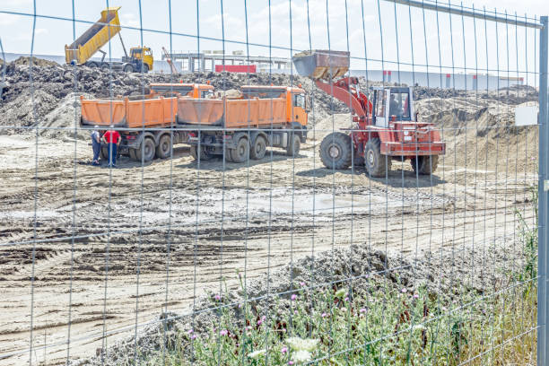 istock Bulldozer is loading a truck on building site in fenced area 660635152
