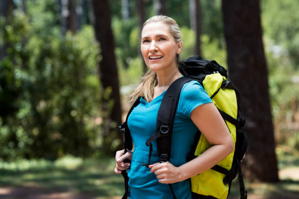 istock Woman looking up and posing with a backpack 660635578