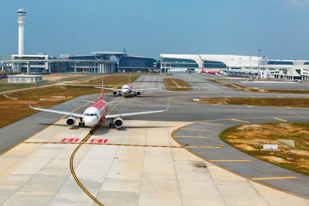 Airplanes in Kuala Lumpur International Airport terminal KLIA 2, Malaysia Kuala Lumpur: Low cost airline Air asia aircrafts waiting for take off on the background of transit passenger terminal building in malaysian international airport KLIA 2 kuala lumpur airport stock pictures, royalty-free photos & images