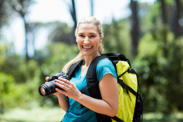 istock Woman smiling and posing with her camera 660639974
