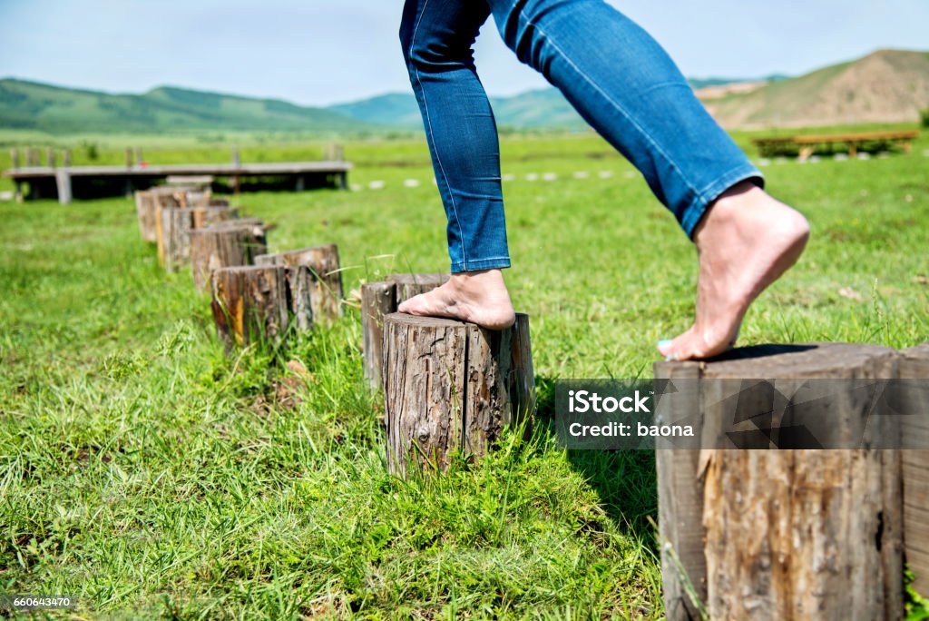 Mujer caminando sobre el tocón del árbol escalonado - Foto de stock de Andar libre de derechos
