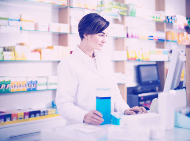 istock female pharmacist offering assistance at counter in pharmacy 660655498