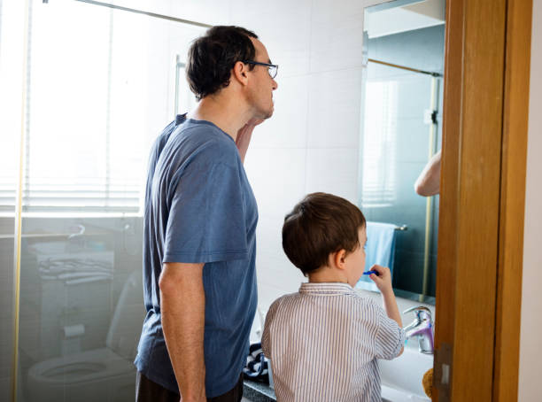 istock Father teaching the son how to brush his teeth 660656210