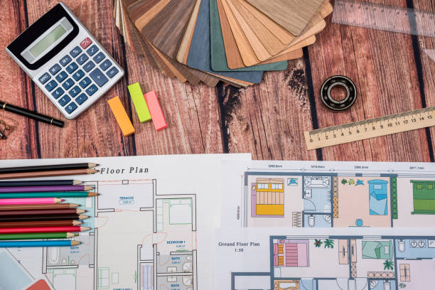 istock house floor paper plan and wooden sampler, work tolls, calculator on wooden table. 660667154