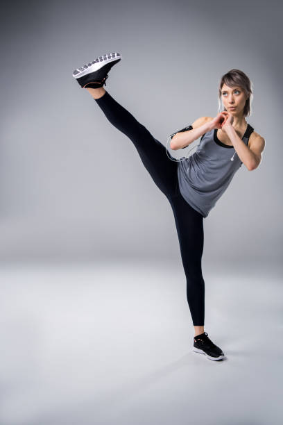 istock woman in sportive clothing training on grey 660671372