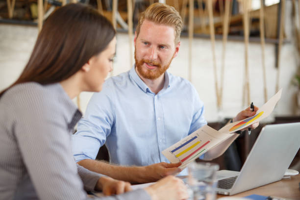 istock Two business people analyzing graphs at meeting in cafe. 660673978