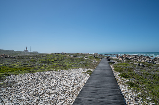 Cape Agulhas is a rocky headland in Western Cape, South Africa. It is the geographic southern tip of the African continent and the beginning of the dividing line between the Atlantic and Indian Ocean