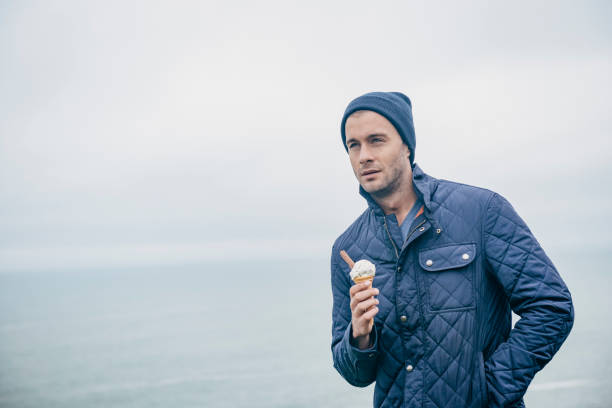 istock Man with ice cream at the Cornish Coast, Newquay, Autumn. 660681376
