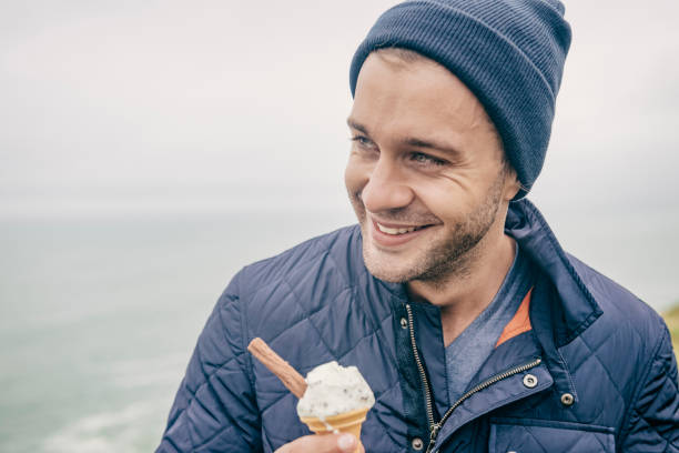 istock Happy man with ice cream, Cornish coast, September. 660681378