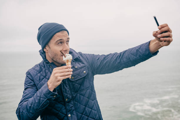 istock Man taking a selfie while eating ice cream, Newquay, Cornwall 660681400