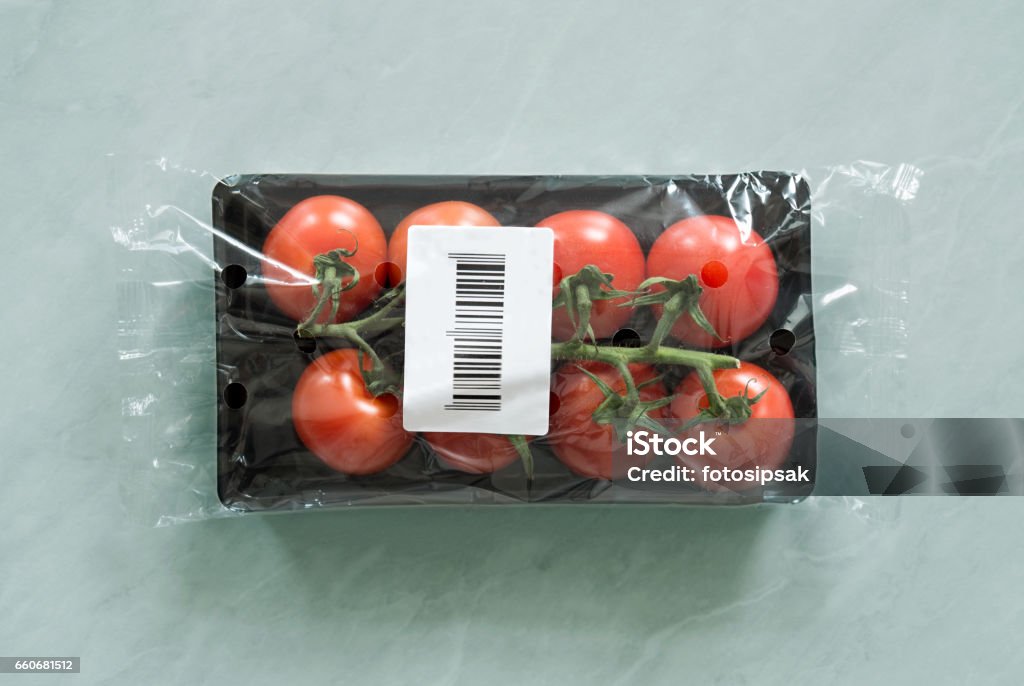 Tomate orgánico dentro del paquete del mercado con la etiqueta de código de barras - Foto de stock de Código de barras libre de derechos