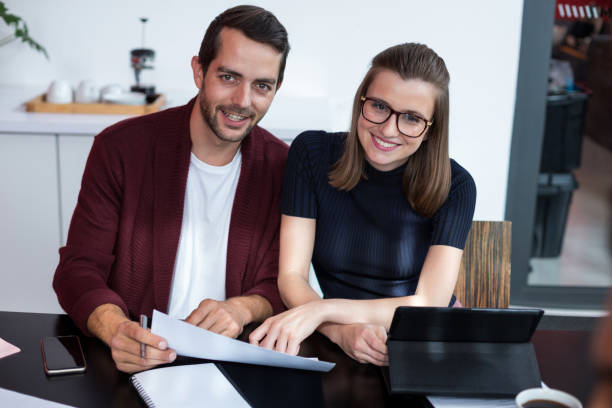 istock Smiling business executives discussing over digital tablet and document in meeting 660681736
