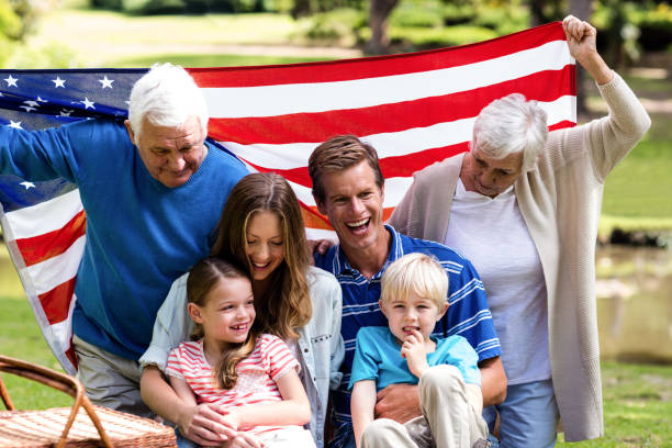 istock Multi-generation family holding american flag in the park 660682702