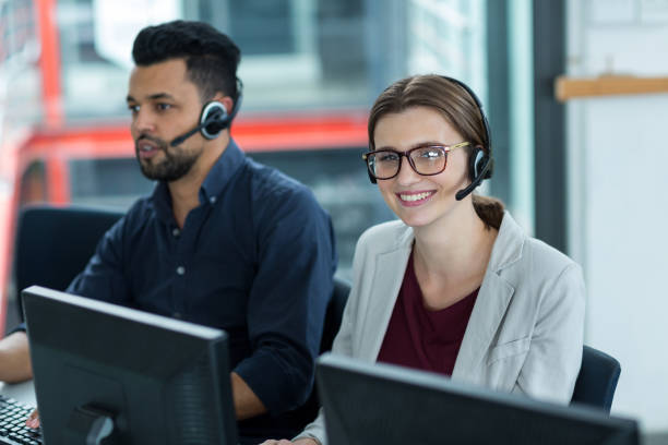 istock Business executives with headsets using computers at desk in office 660687998