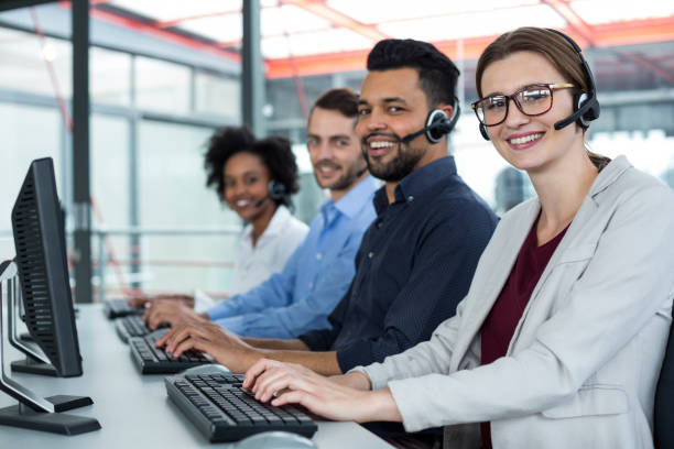 istock Business executives with headsets using computers at desk in office 660688366