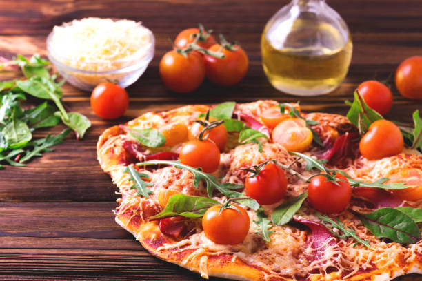 istock Homemade pizza with bacon, tomatoes, spinach, arugula and cheese 660689032