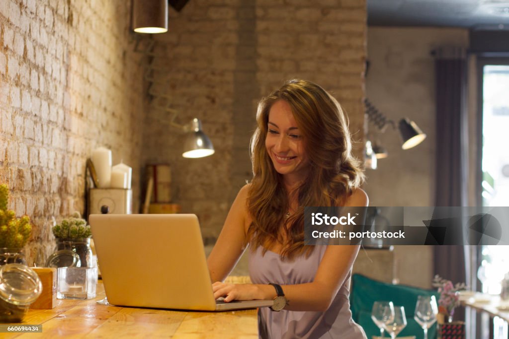 Young woman with computer Young woman in the restaurant using the computer 2017 Stock Photo