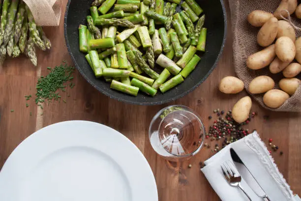 Table decoration with ingredients for asparagus eating on a wooden table close up