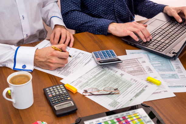 istock two people filling tax forms, helping each other. 660703602
