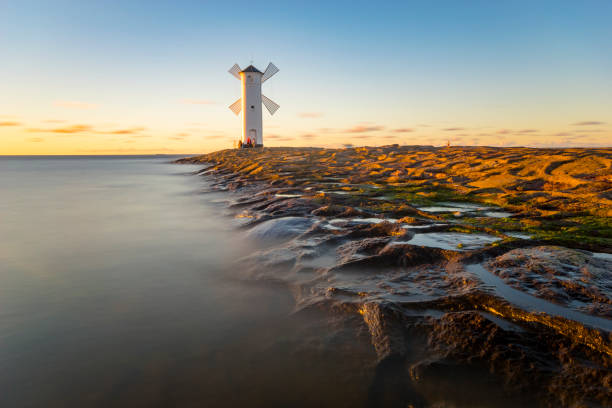 Beautiful sunset over a windmill-shaped lighthouse, Swinoujscie, Poland