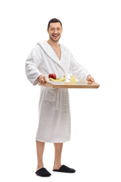 istock Young man in a bathrobe holding a breakfast tray 660710662