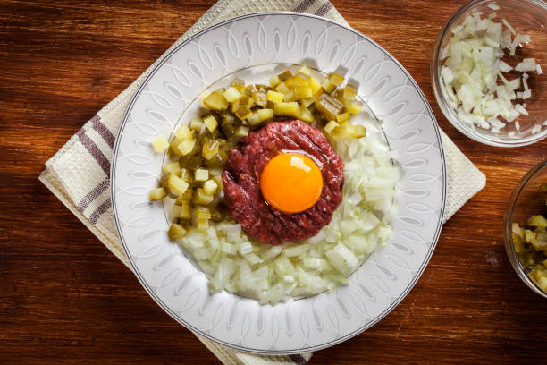 istock Steak tartare with egg yolk, onions and pickles 660715424