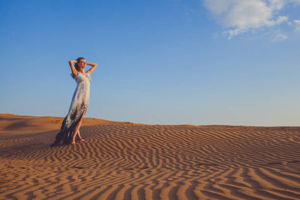 istock slim girl standing in the sand dunes 660719390