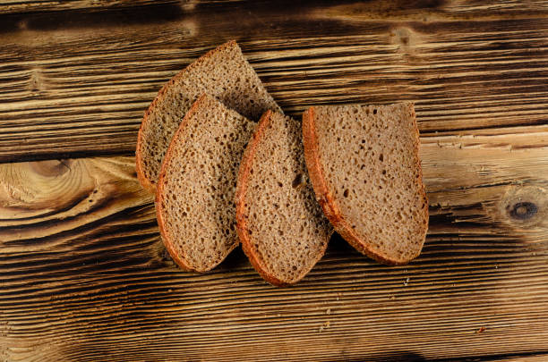 istock Slices of the rye bread on a wooden table. Top view 660725596