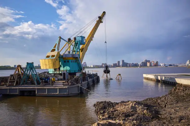 Industrial barge dredging crane work coast. Equipment engineering, reflection in water