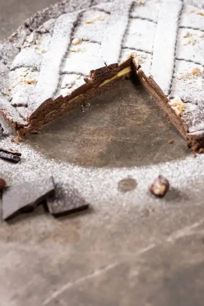 Chocolate Tart Pie Topped with Hazelnuts and Sprinkled with Powdered Sugar