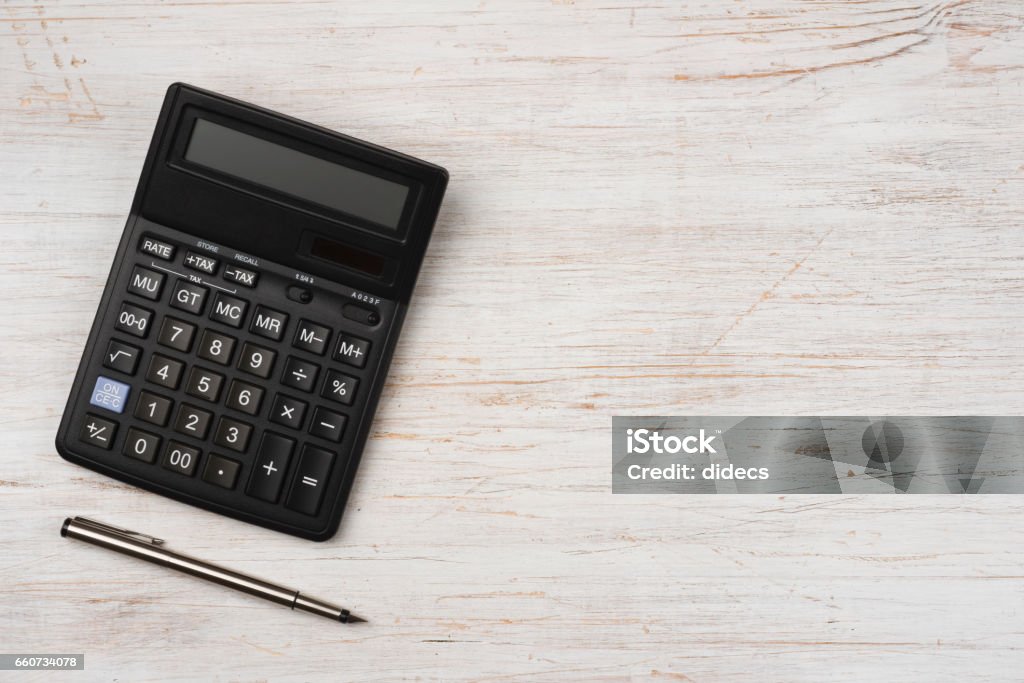 Ink pen and black calculator isolated on wooden texture background Calculator Stock Photo