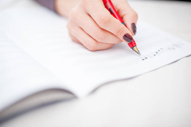 istock Close Up Woman Hands Writing Musical Note 660739794