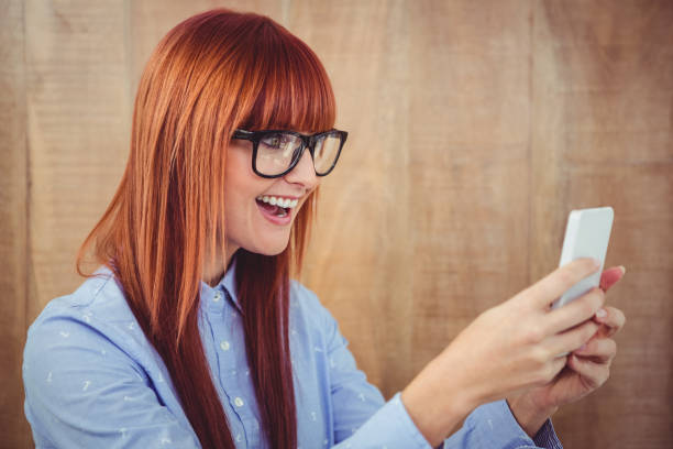 istock Smiling hipster woman texting on her smartphone 660741944