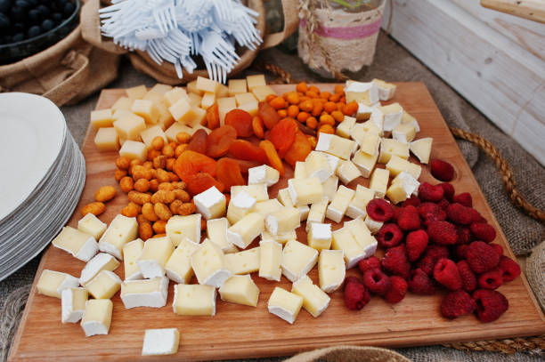 istock Raspberry, cheese and different nuts on wooden board at wedding catering table. 660743958